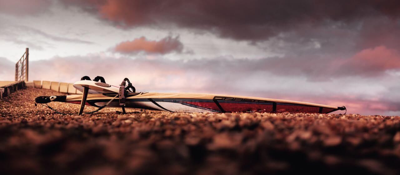 deska i żagiel do windsurfingu leżące na plaży na półwyspie helskim
