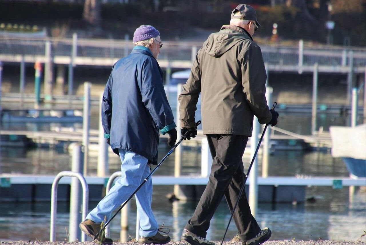 seniorzy uprawiający Nordic Walking nad morzem