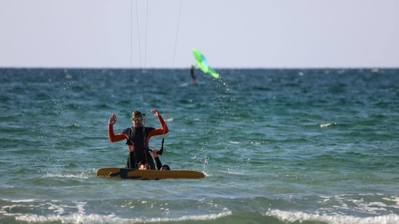 Mężczyzna w piance cieszy się kitesurfingiem na Zatoce Puckiej