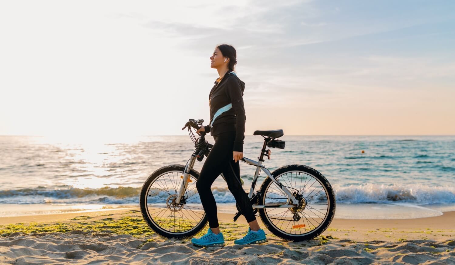 kobieta z rowerem na plaży