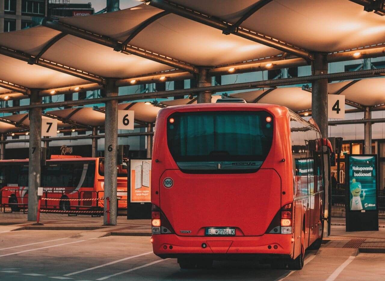 Jasnoczerwony autobus zaparkowany na stacji autobusowej